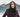Model wearing the Norwegian Wool plum hooded City Coat outdoors in the snow.